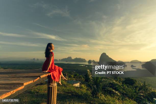 woman in red dress is in view of ao samet nang she phang nga with sea and mountains in phang nga province, thailand - red sea rain stock pictures, royalty-free photos & images