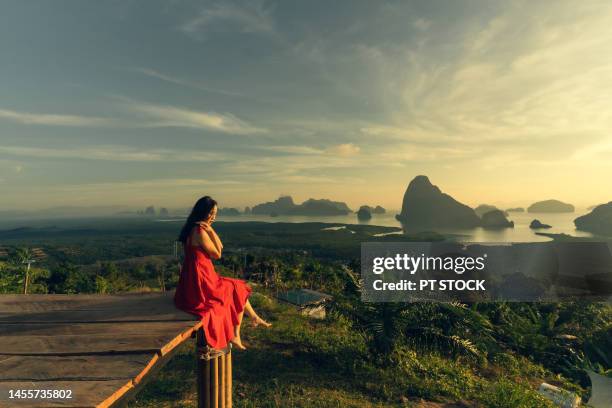 woman in red dress is in view of ao samet nang she phang nga with sea and mountains in phang nga province, thailand - red sea rain stock pictures, royalty-free photos & images