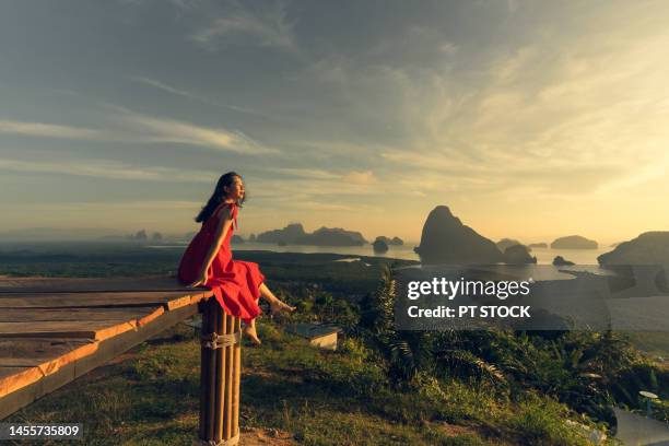 woman in red dress is in view of ao samet nang she phang nga with sea and mountains in phang nga province, thailand - red sea rain stock pictures, royalty-free photos & images