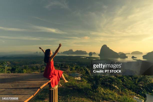 woman in red dress is in view of ao samet nang she phang nga with sea and mountains in phang nga province, thailand - red sea rain stock pictures, royalty-free photos & images