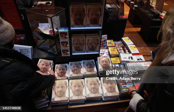 Customers look at copies of Prince Harry’s memoir “Spare” on display at the Dussmann das KulturKaufhaus bookshop, on January 11, 2023 in Berlin,...