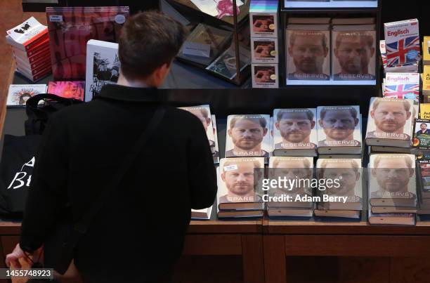 Customer looks at copies of Prince Harry’s memoir “Spare” on display at the Dussmann das KulturKaufhaus bookshop, on January 11, 2023 in Berlin,...