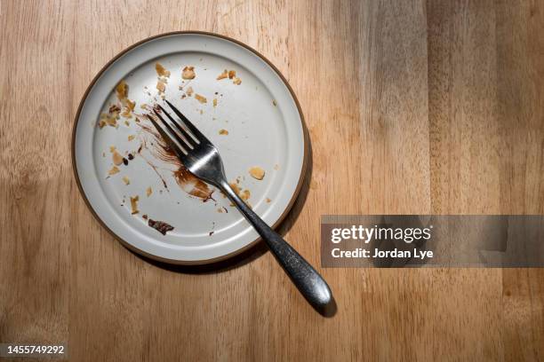 empty dish with pastry crumbs on a wooden table - miga fotografías e imágenes de stock