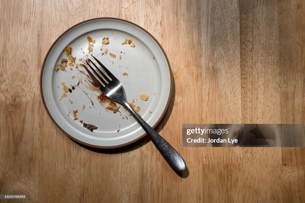 Empty dish with pastry crumbs on a wooden table