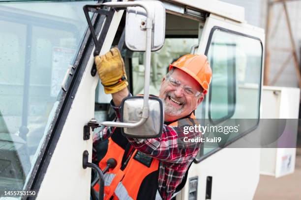 senior man operating a crane, smiling at camera - mobile crane stock pictures, royalty-free photos & images