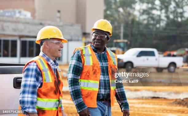 multiracial workers walking, talk at construction site - construction-worker stockfoto's en -beelden