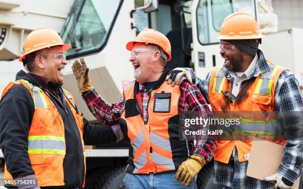 three multiracial construction workers laughing - laugh stock pictures, royalty-free photos & images