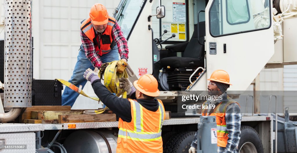 Bauarbeiter bereiten sich auf den Einsatz eines Mobilkrans vor