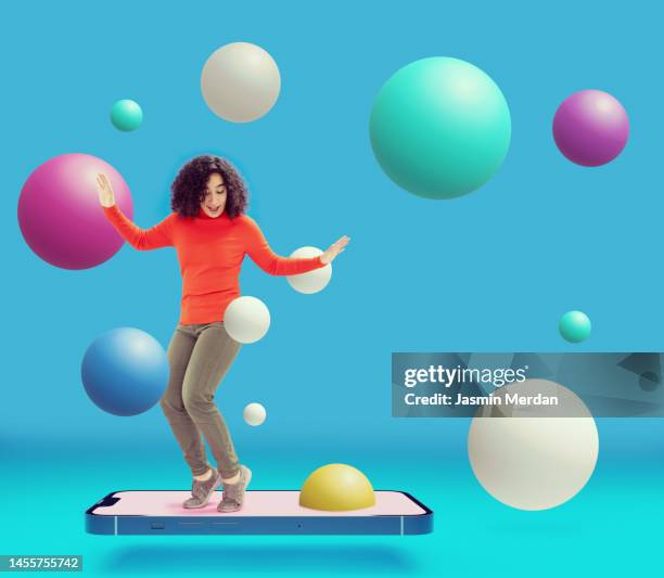 woman standing on smartphone with colourful floating spheres - 1 etappe stock-fotos und bilder