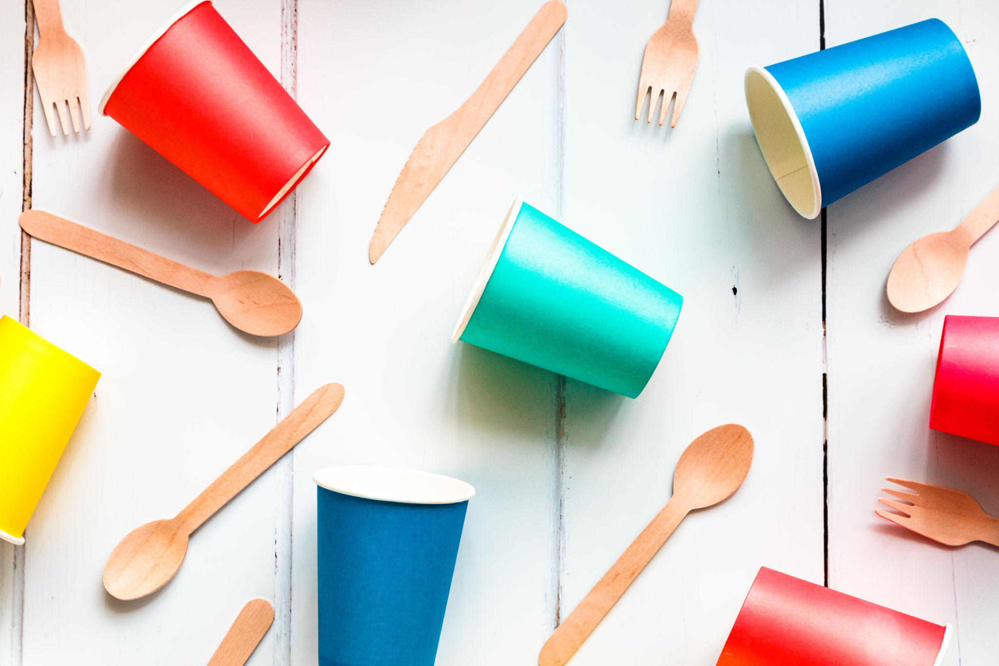 Colorful recyclable paper cups and wooden kitchenware utensils on white background Colorful recyclable paper cups and wooden kitchenware utensils on white background