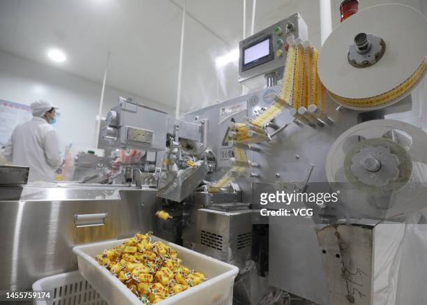 Employees work on the production line of sorghum soft candies at a food factory ahead of Chinese New Year, the Year of the Rabbit, on January 10,...