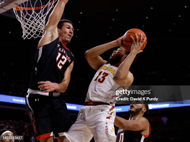 Jaren Holmes of the Iowa State Cyclones drives the ball as Daniel Batcho of the Texas Tech Red Raiders and Kevin Obanor of the Texas Tech Red Raiders...