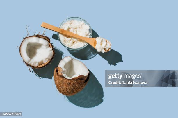 ripe coconuts, coconut oil on blue background. health and wellness concept. minimal flat lay style. top view, copy space. - coconut oil foto e immagini stock