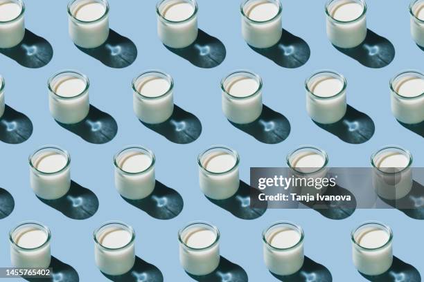 pattern of glass of organic fresh milk glass of milk on blue background. dairy, grow and drink concept. minimal flat lay style. top view. - yogurt fotografías e imágenes de stock