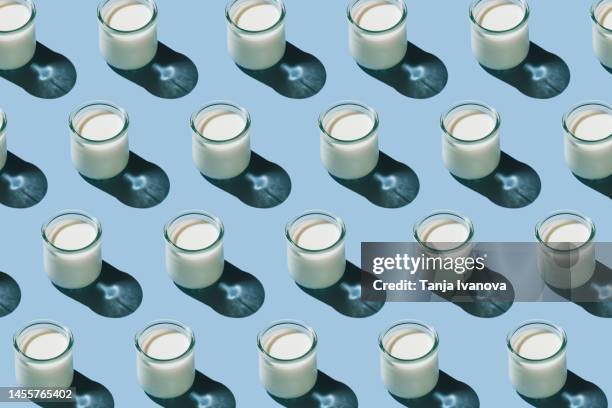 pattern of glass of organic fresh milk glass of milk on blue background. dairy, grow and drink concept. minimal flat lay style. top view. - yoghurt stock pictures, royalty-free photos & images