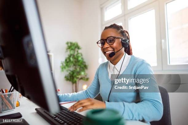 customer support specialist working at her office - headset imagens e fotografias de stock