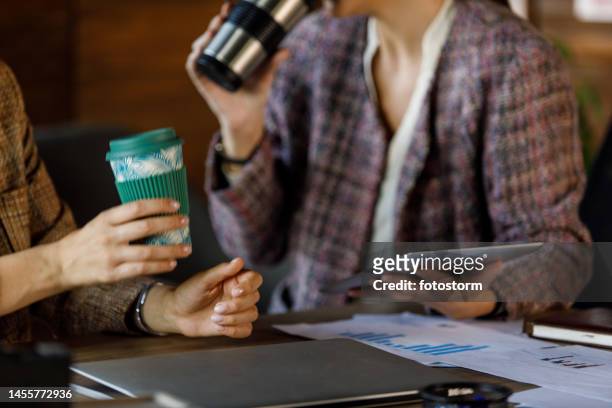 two businesswomen having coffee and chatting during office break - drinks flask stock pictures, royalty-free photos & images