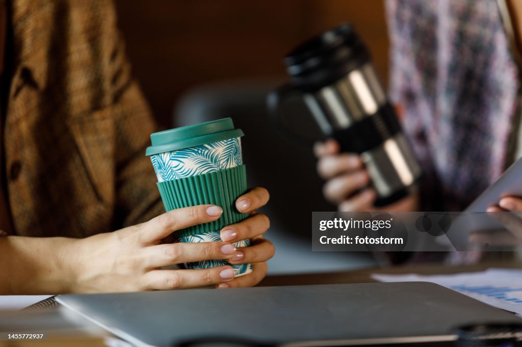 Zwei Geschäftsfrauen trinken Kaffee und plaudern in der Büropause