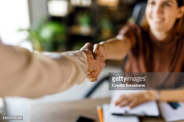 two businesswomen shaking hands when meeting to collaborate on a project - handshake closeup stock pictures, royalty-free photos & images