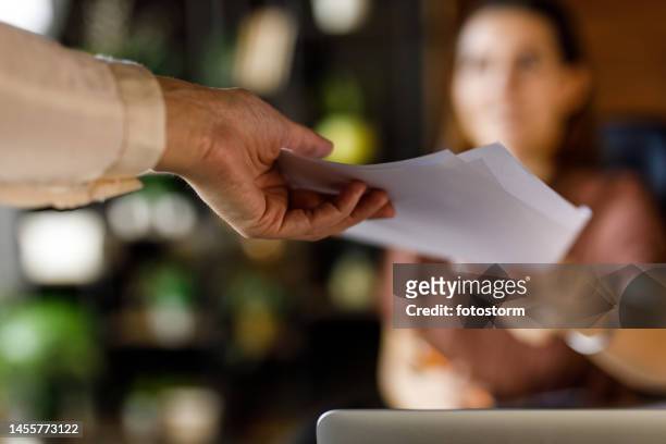 businesswoman handing her colleague a document - paperwork 個照片及圖片檔