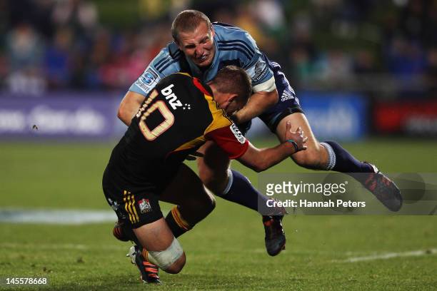 Aaron Cruden of the Chiefs tackles Hadlee Parkes of the Blues during the round 15 Super Rugby match between the Blues and the Chiefs at North Harbour...