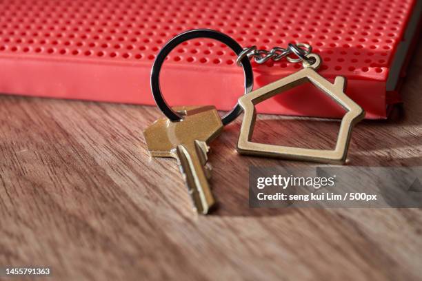 house key with home keyring,blank notebook and pencil on wood table background,malaysia - porta chave imagens e fotografias de stock