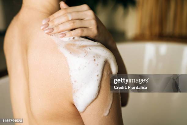 washing with shower foam for washing the body in female hands. relaxation and beauty treatments. natural beauty, daily skincare routine. moisturizing, cleansing - hand washing stock-fotos und bilder