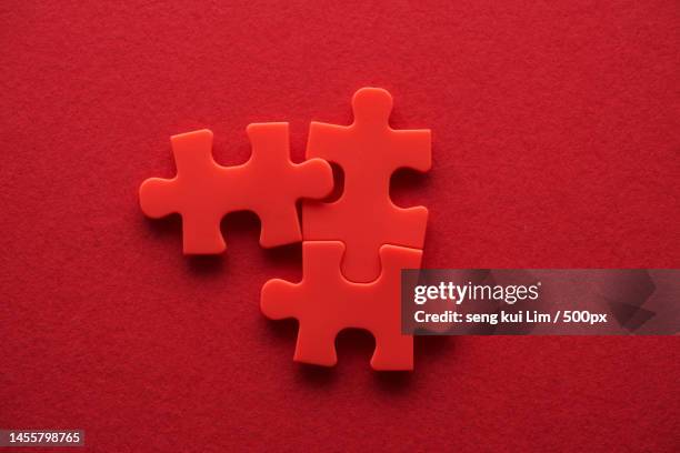 three pieces of jigsaw puzzle against red background,malaysia - hand white background stock pictures, royalty-free photos & images