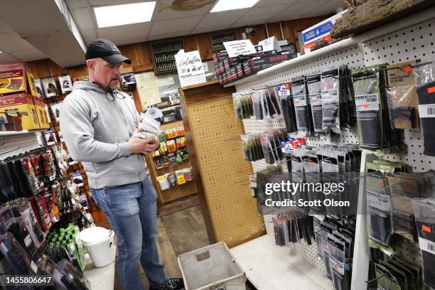 Matt Collins removes high capacity rifle magazines from display at Freddie Bear Sports on January 11, 2023 in Tinley Park, Illinois. Yesterday...