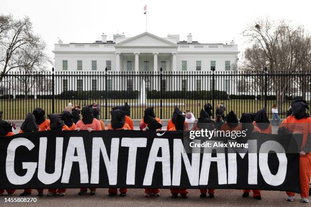 Activists in orange jumpsuits, representing the 35 men who are still being held at the U.S. Detention facility in Guantanamo Bay, Cuba, participate...