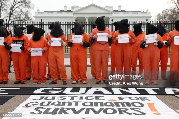 Activists in orange jumpsuits, representing the 35 men who are still being held at the U.S. Detention facility in Guantanamo Bay, Cuba, participate...
