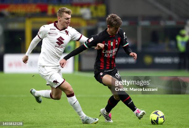 Charles De Ketelaere of AC Milan runs with the ball whilst under pressure from Perr Schuurs of Torino FC during the Coppa Italia match between AC...