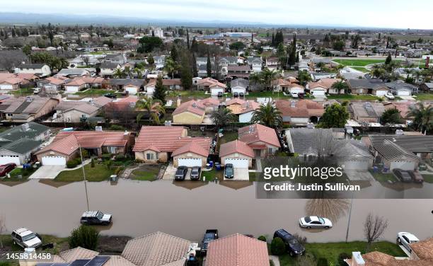 In an aerial view, homes are seen surrounded by floodwaters on January 11, 2023 in Planada, California. The Central Valley town of Planada was...