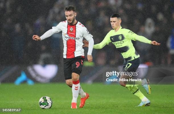 Adam Armstrong of Southampton battles for possession with Phil Foden of Manchester City during the Carabao Cup Quarter Final match between...