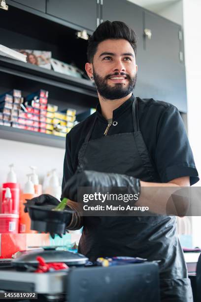 professional hairdresser prepares dye color on black container - color dye stock pictures, royalty-free photos & images