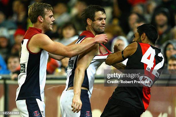 Nathan Lovett-Murray of the Bombers wrestles with Jack Watts and Jared Rivers of the Demons during the round 10 AFL match between the Essendon...