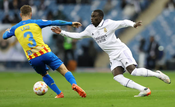 Ferland Mendy of Real Madrid runs with the ball whilst under pressure from Toni Lato of Valencia CF during the Super Copa de Espana match between...