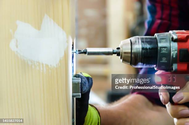 close-up view of carpenter using a drill. - hand tool stock pictures, royalty-free photos & images