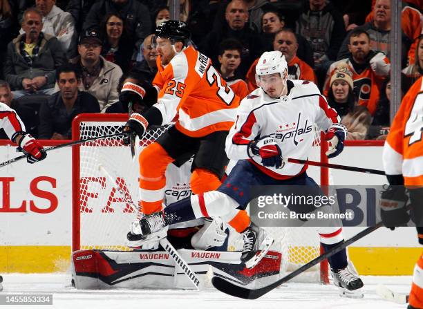 Darcy Kuemper and Dmitry Orlov of the Washington Capitals defend against James van Riemsdyk of the Philadelphia Flyers during the first period at the...