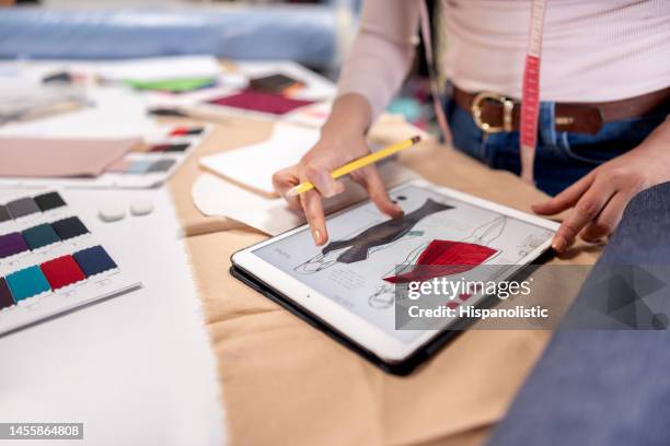 designer de moda desenhando vestidos em seu ateliê usando um tablet - hi tech moda - fotografias e filmes do acervo