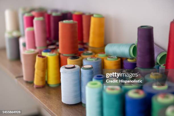 sewing thread cones at a fashion atelier - fabric spool stock pictures, royalty-free photos & images