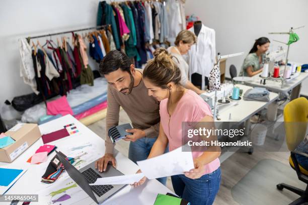 diseñadores de moda trabajando juntos en un taller de ropa - textile industry fotografías e imágenes de stock