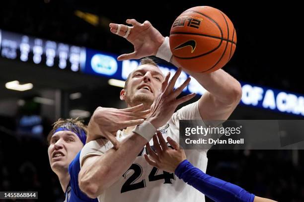 Baylor Scheierman of the Creighton Bluejays and Jack Nunge of the Xavier Musketeers battle for a rebound in the second half at the Cintas Center on...