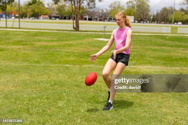 ragazza adolescente con un football australiano - afl woman foto e immagini stock