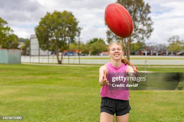 teenage girl with an australian rules football - afl australian football league stock pictures, royalty-free photos & images