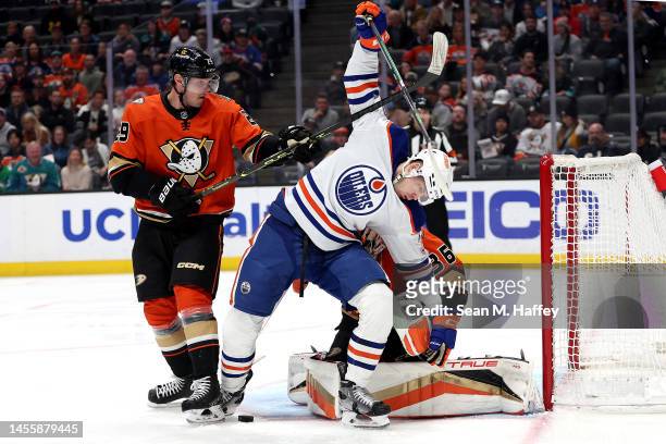 John Gibson and Dmitry Kulikov of the Anaheim Ducks push Warren Foegele of the Edmonton Oilers out of the crease during the first period of a game at...