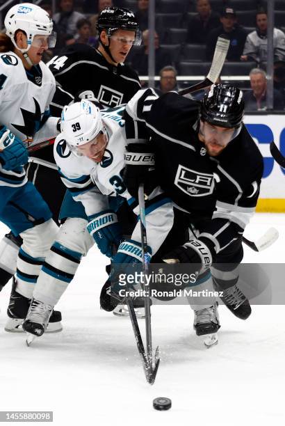 Anze Kopitar of the Los Angeles Kings skates the puck against Logan Couture of the San Jose Sharks in the first period at Crypto.com Arena on January...