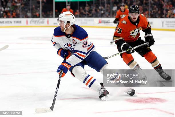 Connor McDavid of the Edmonton Oilers controls the puck past the defense of Troy Terry of the Anaheim Ducks during the second period of a game at...