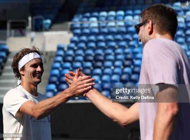 Dirk Nowitzki and Alexander Zverev shake hands during media opportunity ahead of the 2023 Australian Open at Melbourne Park on January 12, 2023 in...
