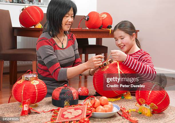 mother and daughter preparing for chinese new year - woman red lantern stock pictures, royalty-free photos & images